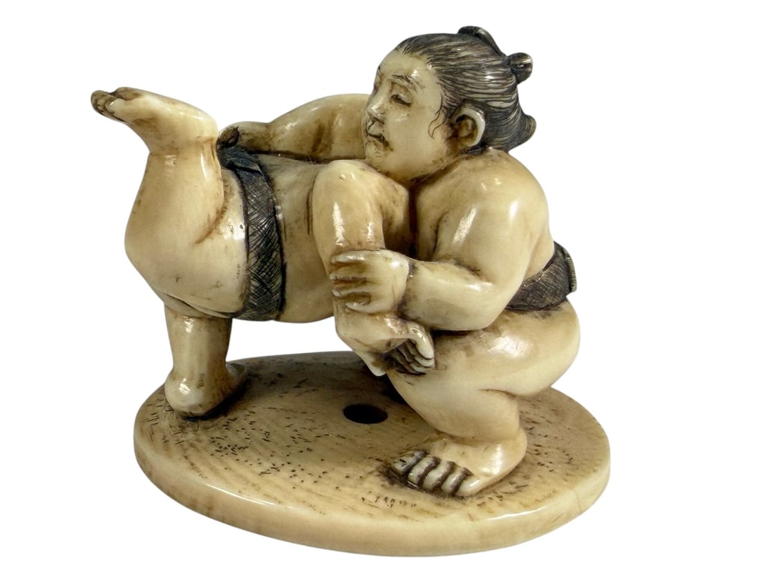 Japanese Sumo Wrestlers Okimono Signed Seizan Fine: Japanese carved okimono depicting two sumo wrestlers engaged in a dynamic grappling pose on an oval base. Finely detailed with expressive faces, traditional topknots, engraved hair, textured mawashi, 