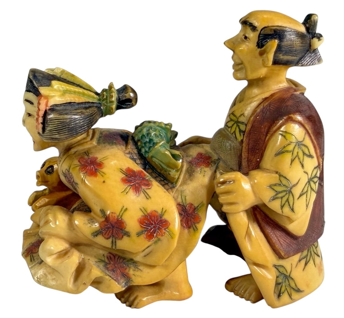 Japanese Netsuke Erotic Scene Gyokuho Seal: Japanese carved and polychrome netsuke depicting an erotic (shunga) scene with an elderly man, a kneeling courtesan, and a small child. Finely carved with engraved floral kimono decoration and express