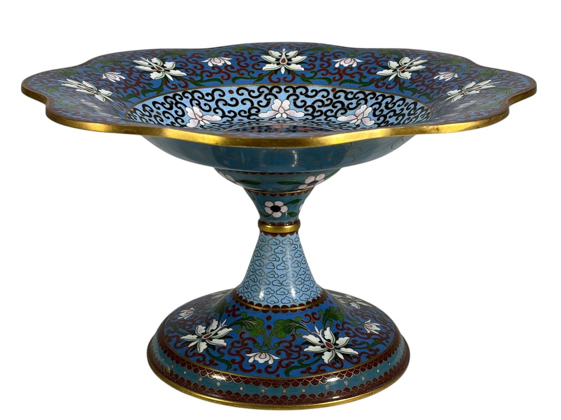 Chinese Cloisonne Pedestal Compote Bowl: Chinese bronze-mounted cloisonne enamel pedestal compote bowl with a scalloped rim, decorated with floral motifs and scrolling designs in polychrome enamels on a light blue ground with gilt accents.