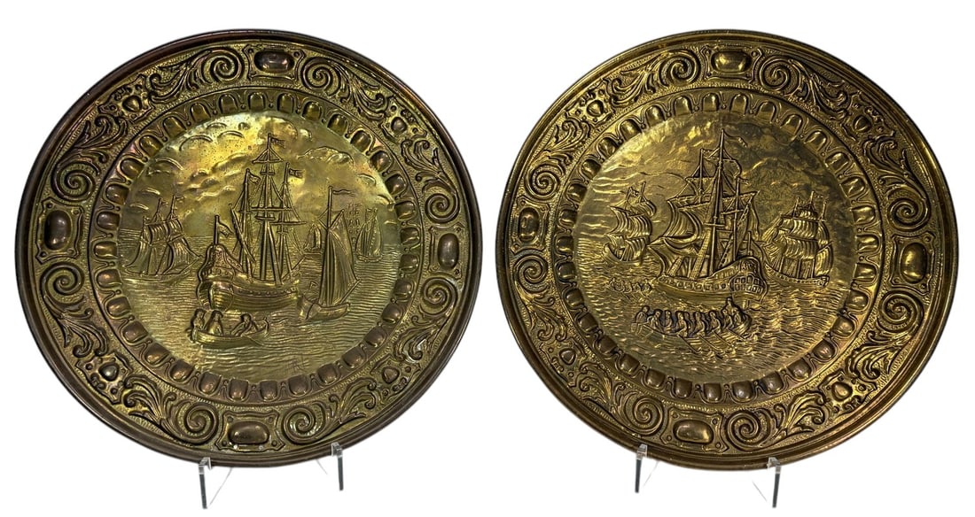 Pair Bronze Wall Plaques Sailing Ships: Pair of decorative embossed brass sheet wall plaques featuring sailing ship scenes in relief with ornate scrolling borders. Designed for wall display, each measures approximately 17 x 17 inches.