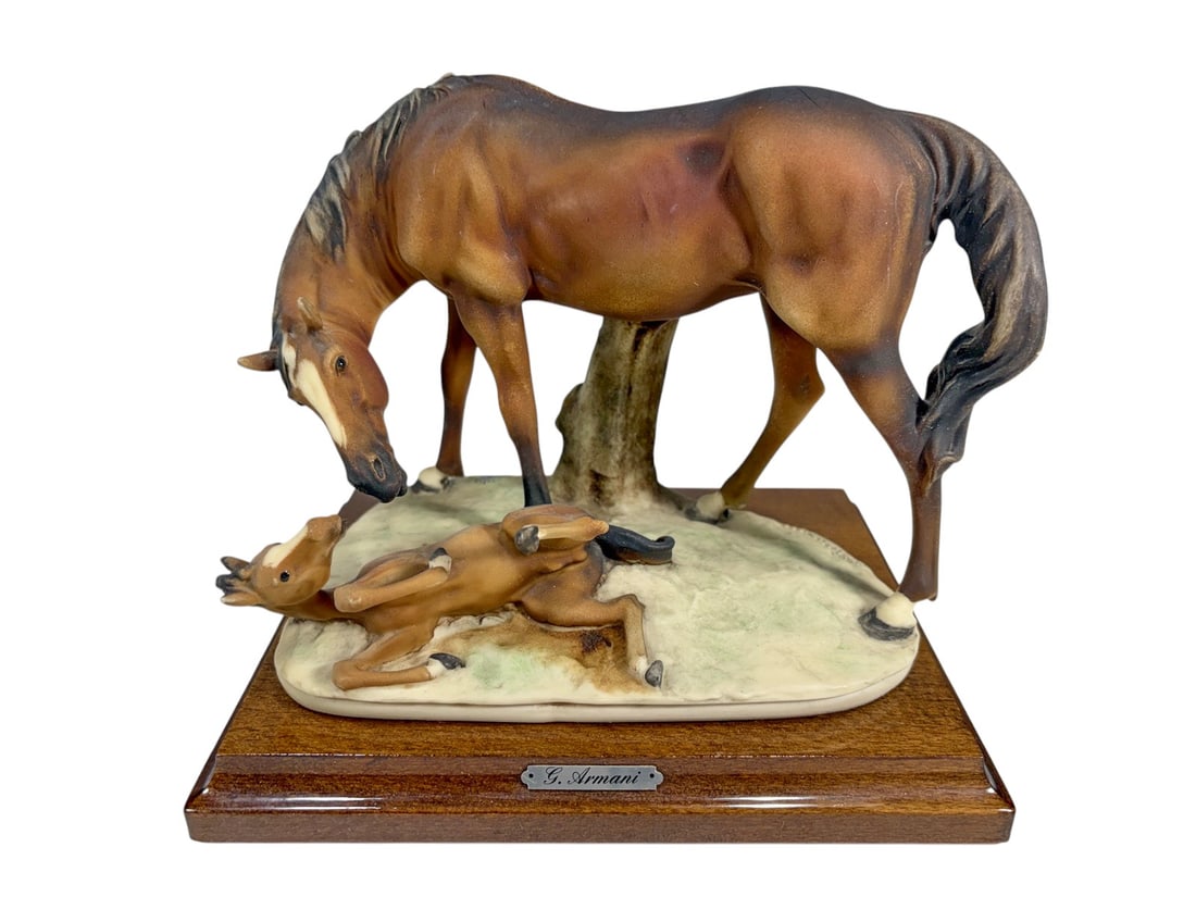 Giuseppe Armani Mare & Foal Figurine on Wood Base: Giuseppe Armani mare and foal figurine mounted on a wood base. Finely modeled composition depicting a mare nuzzling her newborn foal beside a tree stump. Retains the metal G. Armani name plaque on the