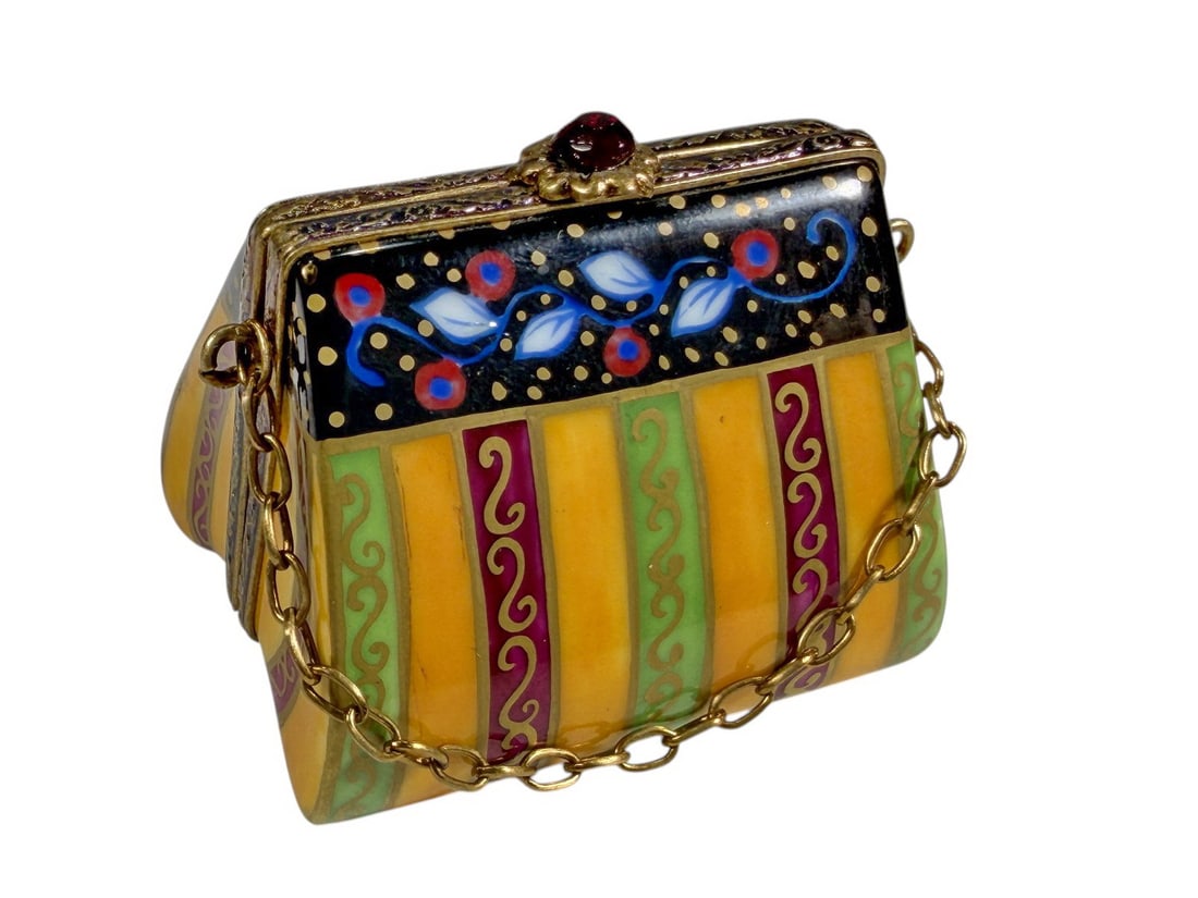 Limoges Purse Trinket Box w Heart Gem Hand Painted: Hand-painted Limoges France porcelain trinket box in the form of a lady's handbag with gilt-tone metal mounts and decorative chain. The interior features a faceted heart-shaped gemstone mounted inside