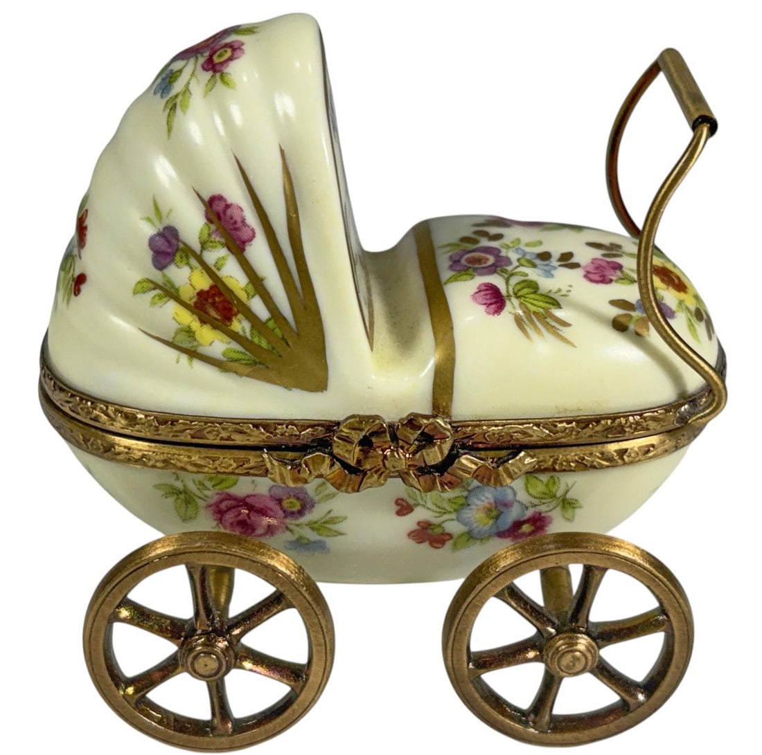 Rochard Limoges Baby Carriage Trinket Box France: Hand-painted Rochard Limoges France porcelain trinket box in the form of a baby carriage with gilt-tone metal mounts and wheels. Decorated with floral motifs and a baby scene on the hood interior. Mar