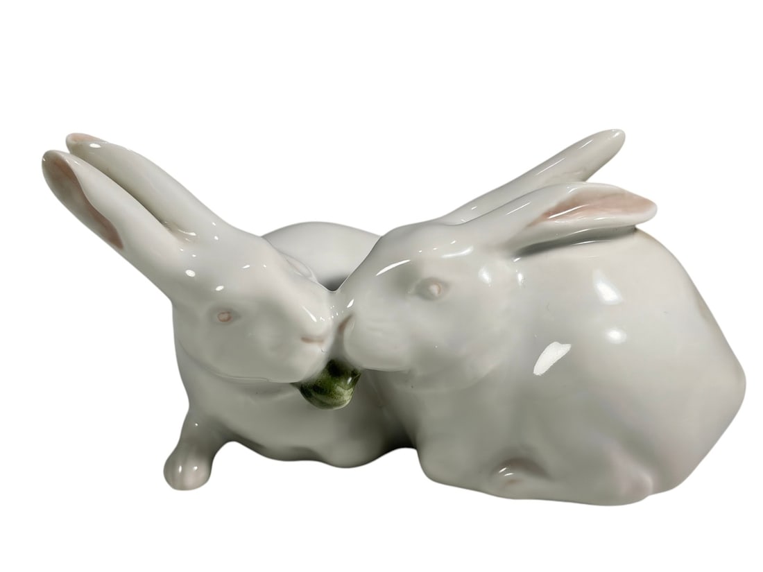 Royal Copenhagen Rabbits Porcelain Figurine Pair: Royal Copenhagen porcelain figurine depicting two rabbits sharing a leafy sprig. Executed in the factory's characteristic naturalistic style with soft white glaze and subtle pink accents to the ears. 