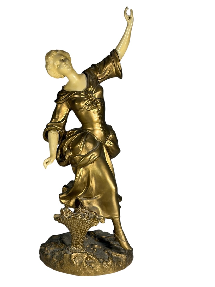 French Bronze Figural Sculpture by Somme Signed: French solid bronze figural sculpture by Somme, depicting a graceful young woman in flowing attire standing beside a basket of flowers. Signed "Somme" on the base. The figure features an bone-tone hea