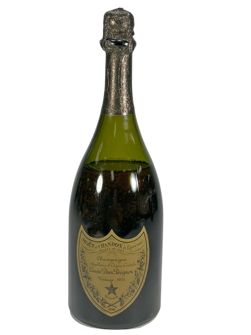 1976 Dom Perignon Vintage Champagne Bottle, 750 ml: Vintage 1976 Dom Perignon Champagne by Moet et Chandon, dpernay, France, in a dark green 750 ml glass bottle. Front label identifies Cuvee Dom Perignon, Vintage 1976. Rear importer label reads