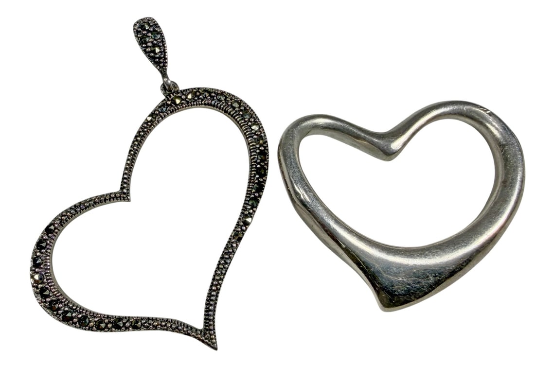 Sterling Silver Heart Pendants, Peretti Style 2pcs: Group of two sterling silver open heart pendants. One features a smooth sculptural form in the style of Elsa Peretti, measuring approximately 1.75 x 1.75 in. The second features a textured border