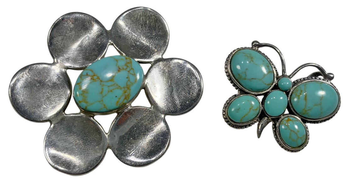 Navajo Sterling 925 Turquoise Pendants 2pc LOT: Group of two Navajo style sterling silver 925 pendants set with turquoise cabochons. One pendant features a butterfly form with multiple oval turquoise stones. The second features a stylized flower