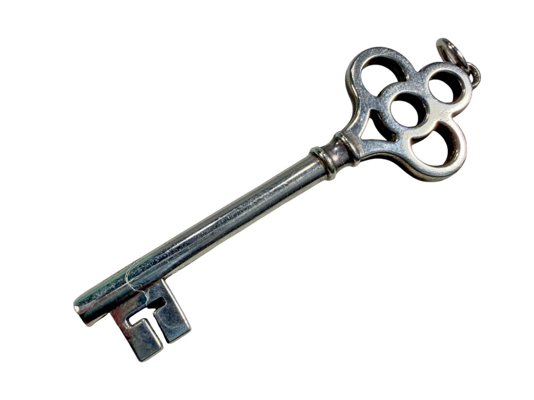Tiffany & Co. Sterling Silver 925 Key Pendant 8.9g: Tiffany & Co. sterling silver key pendant featuring an openwork quatrefoil-style bow and classic key form. The shaft is engraved (C) Tiffany & Co. 925, indicating sterling silver. Includes a Tiffany