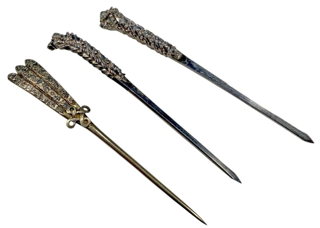 Chinese Foliate Silver Ornamental Hairpins 3pc LOT: Set of three Chinese ornamental hairpins crafted in silver or low-grade silver, including a matching pair with raised foliate decoration and a third example with three engraved prongs and an openwork 
