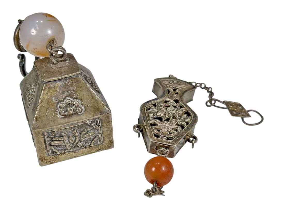 Chinese Figural Low-Grade Silver Ornaments 2pc LOT: Two Chinese ornamental pieces crafted in low-grade silver. One is a house-shaped rattle decorated with applied floral motifs, engraved details, a Chinese character on the base, and a pale agate or gla