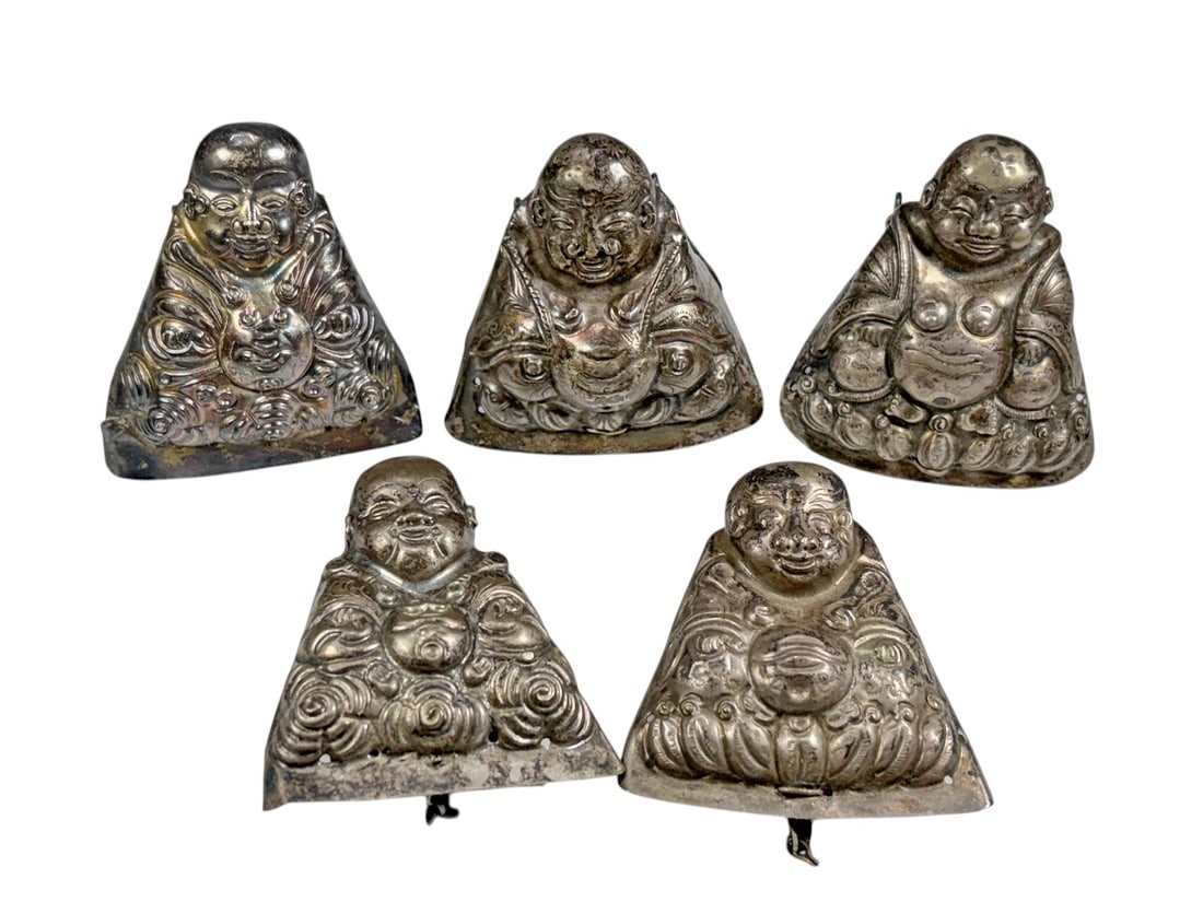 Chinese Low-Grade Silver Figural Ornaments 5pc LOT: Set of five Chinese figural ornaments, four crafted in silver and one in low-grade silver, each modeled as a seated smiling monk or auspicious figure with detailed robes and varied decorative attribut