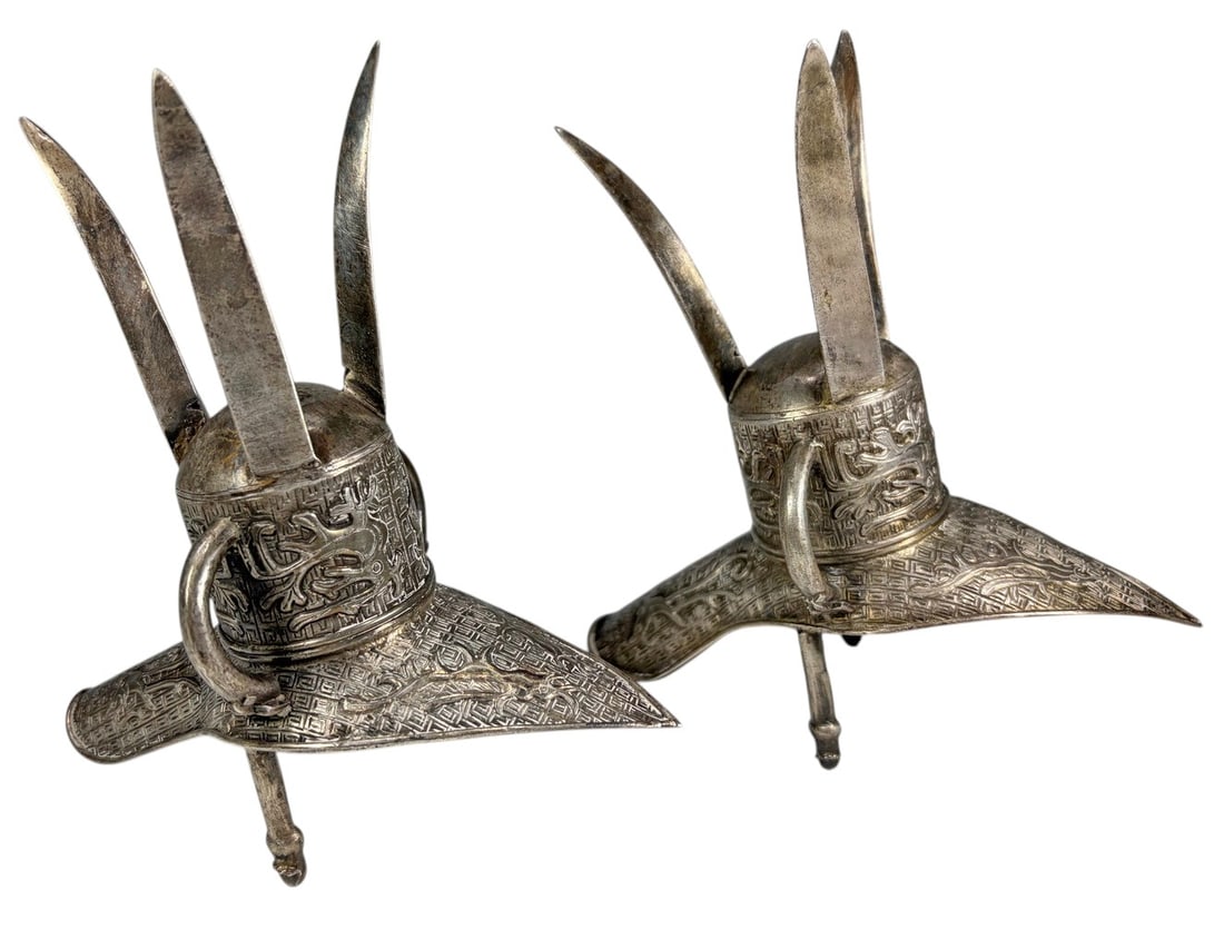 Chinese Low-Grade Silver Archaistic Jue Cups 2pcs: Pair of Chinese low-grade silver archaistic ritual wine vessels modeled after ancient jue cups, each raised on three blade-form legs with a cylindrical body, flared spout, upright posts, and side hand