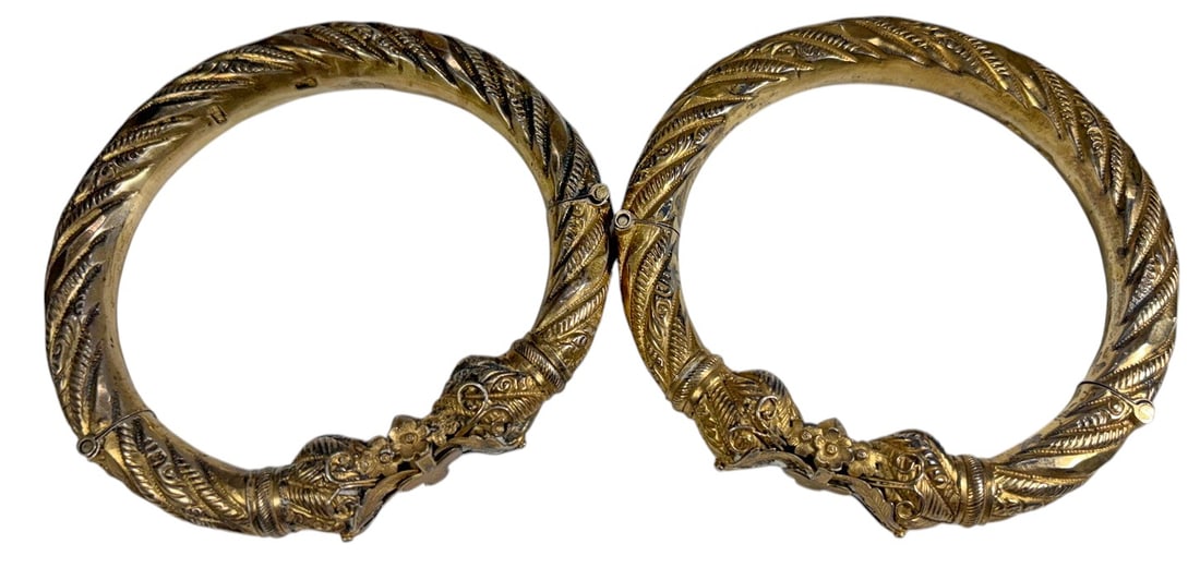 Tibetan-Style Silver Tone Hinged Bracelets 2pc LOT: Pair of Tibetan-style articulated bracelets with elaborate repousse-style and engraved decoration, featuring twisted feather and foliate motifs throughout. Each bracelet is constructed in hinged secti
