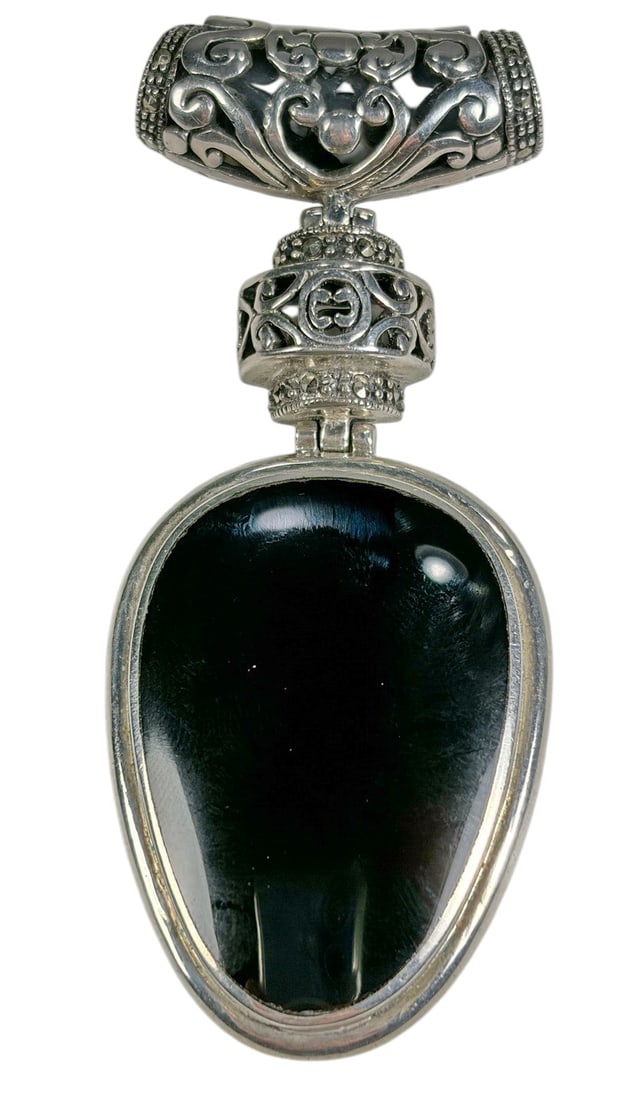 Sterling Silver 925 Large Black Onyx Pendant: Sterling silver pendant featuring a large polished oval black stone, likely onyx, set within a substantial silver frame. The pendant has an ornate openwork bail with scrolling foliate decoration and a