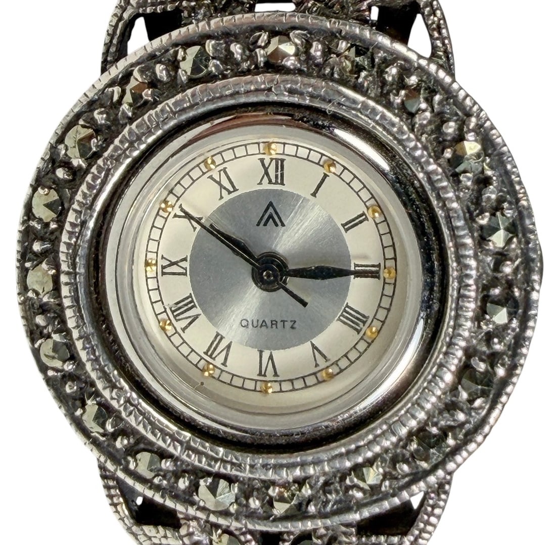 Sterling Silver Marcasite Quartz Wristwatch 55 g.: Sterling silver quartz wristwatch featuring an ornate braided mesh bracelet with decorative openwork panels accented with faceted marcasite-style stones. The round silver-tone dial displays black Roma