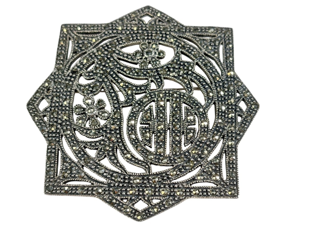 Sterling Silver Marcasite Openwork Brooch 26.8 g.: Sterling silver openwork brooch featuring an ornate geometric and floral design accented throughout with numerous faceted marcasite stones. The composition includes scrolling motifs, floral elements, 