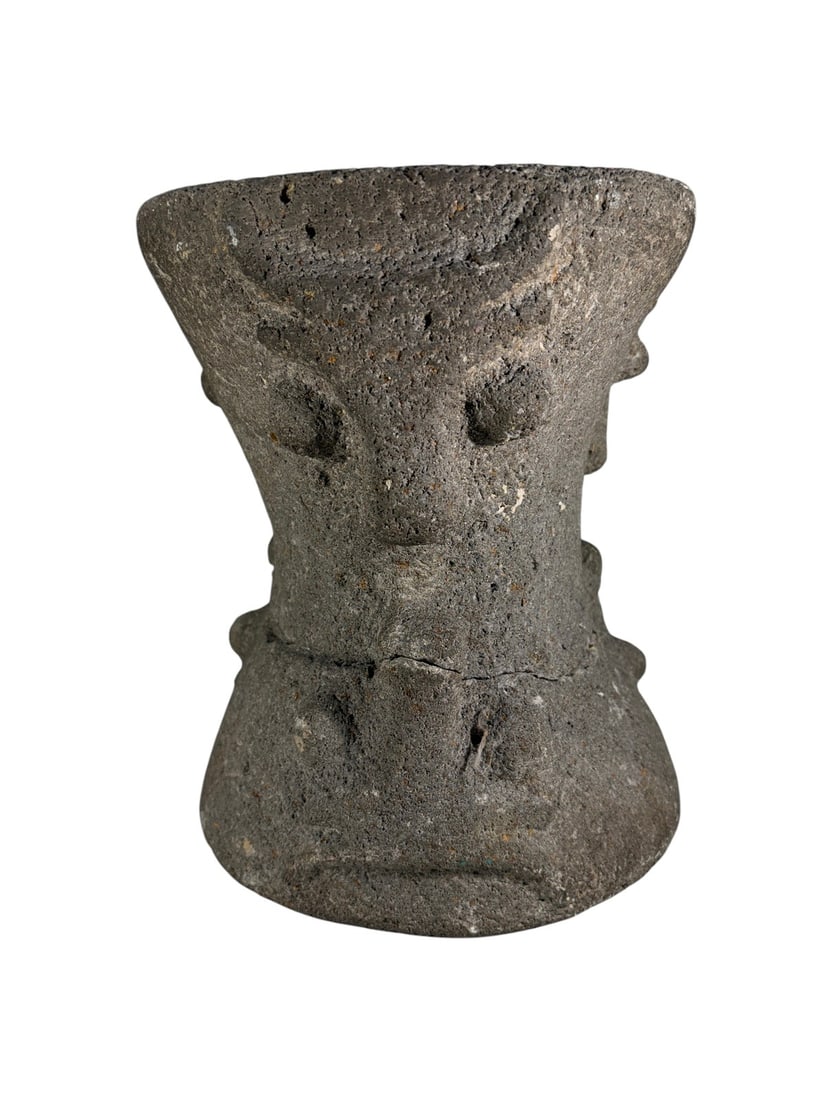Carved Stone Anthropomorphic Figure Sculpture: Heavy carved stone anthropomorphic sculpture with a stylized human face, pronounced facial features, broad headdress-like upper section, and compact cylindrical form. The coarse-grained gray stone sur