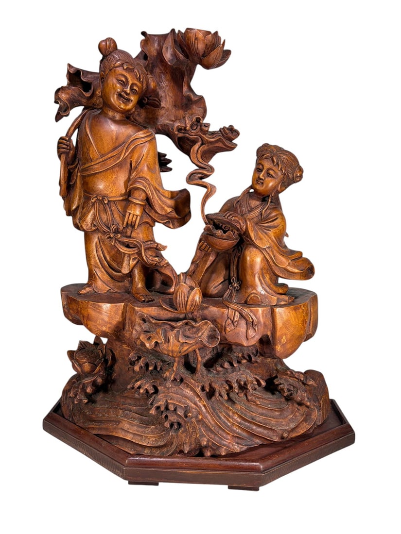Chinese Carved Wood Figural Group with Lotus Scene: Large Chinese carved wood figural group depicting two traditionally dressed figures beneath a flowering lotus tree, accompanied by elaborate carved botanical and mythical decorative elements. The comp