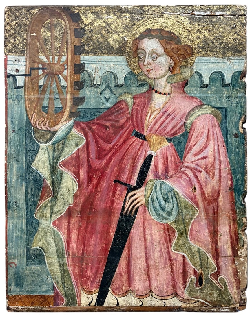 Saint Catherine w/ Wheel Gold-Ground Panel 26.5": Gold-ground religious panel depicting Saint Catherine of Alexandria holding her spiked wheel, set before a crenellated architectural background with punched and tooled decoration. She wears an
