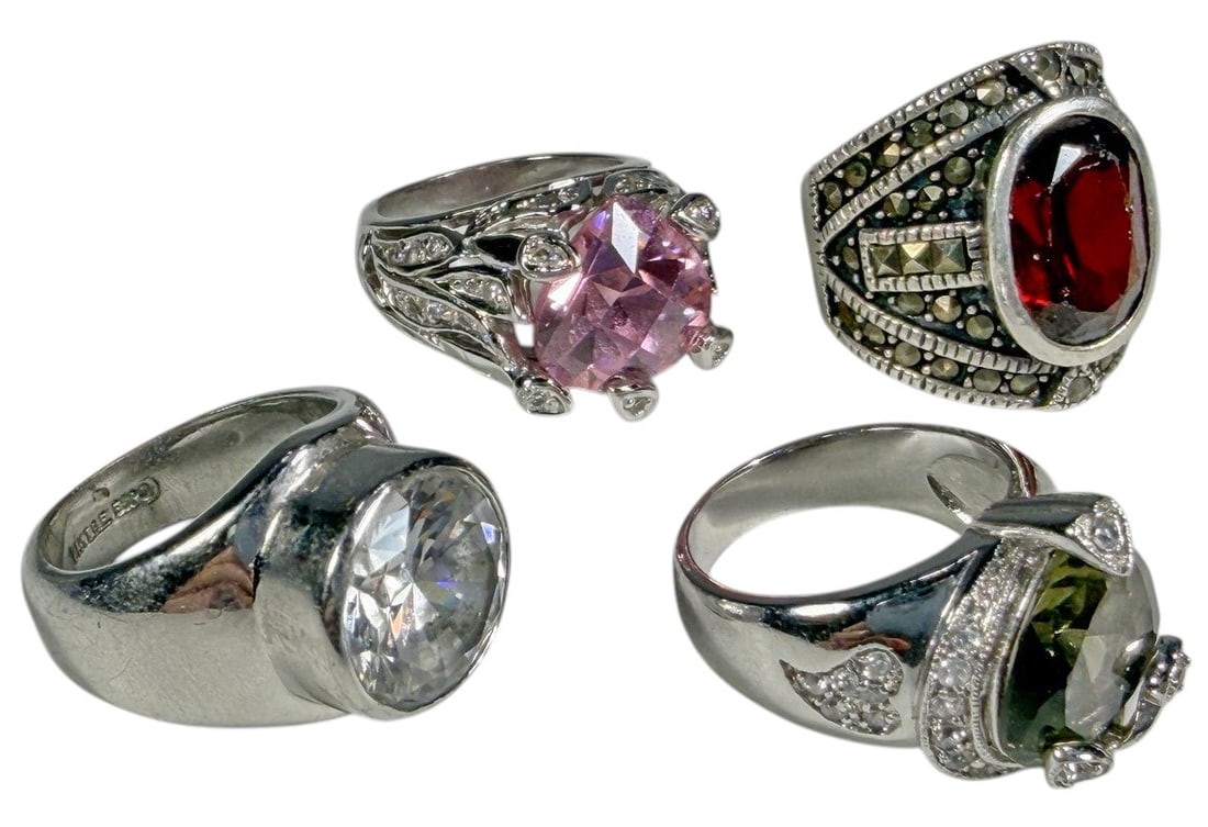 Assorted Sterling Silver Crystal Rings 4pc LOT: Assorted collection of four sterling silver rings, each set with a different faceted crystal stone in varying colors, including clear, pink, orange-red, and pale green tones. The rings feature a mix