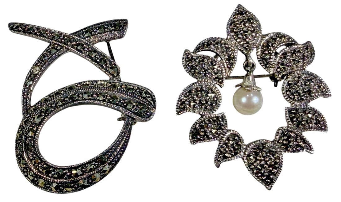 Vintage Sterling Silver Marcasite Brooches 2pc LOT: Pair of vintage sterling silver brooches accented with marcasite. One features an abstract looping ribbon design densely set with marcasite stones. The second is designed as an open floral wreath