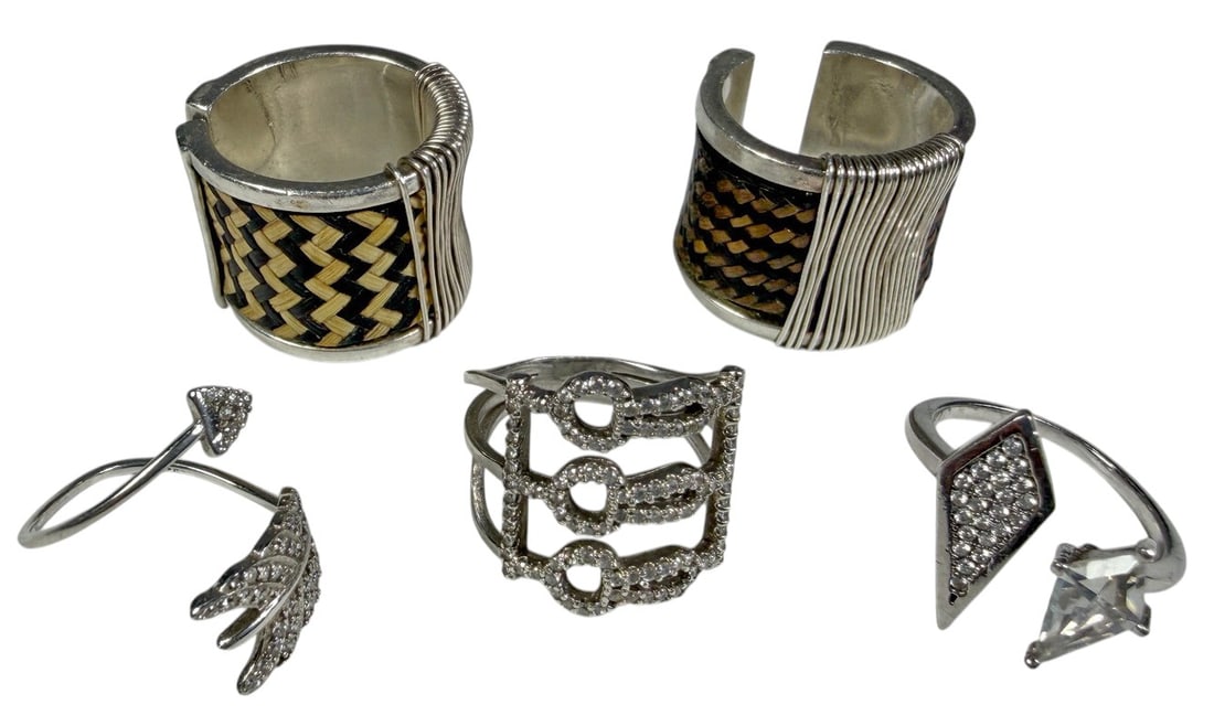 Assorted Sterling Silver Clear Stone Rings 5pc LOT: A lot of five decorative sterling silver rings in assorted contemporary designs. The group includes geometric and openwork rings accented with clear stones, a wraparound feather-form ring, and two