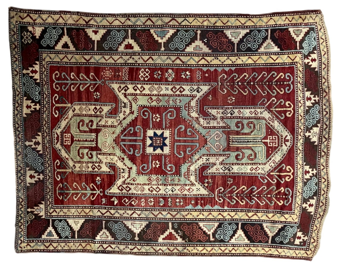 Antique Sewan Kazak Geometric Wool Area Rug: Antique Sewan Kazak-style wool rug featuring a bold geometric composition centered by a large stepped medallion on a deep red field. The design is enriched with stylized botanical and tribal motifs in
