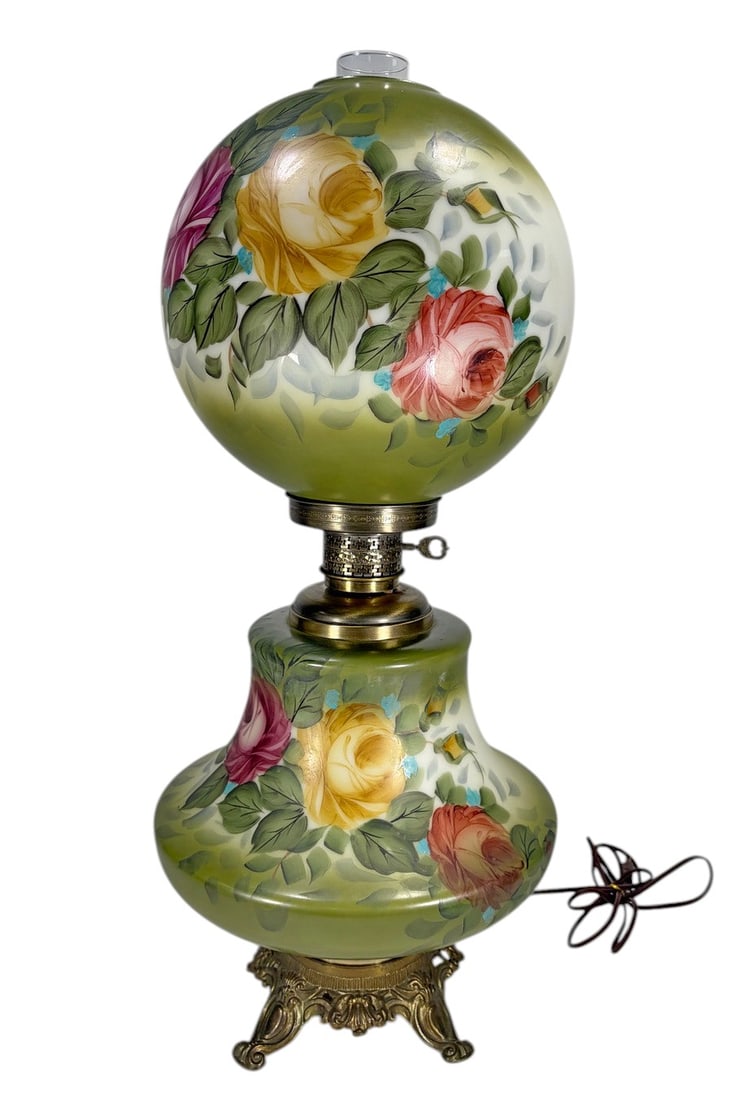 Vintage Floral Glass Hurricane Table Lamp 27": Vintage table lamp with a green and white glass body and matching spherical glass shade, both decorated with hand-painted roses and floral motifs. Fitted with brass-tone metal mounts, ornate footed ba