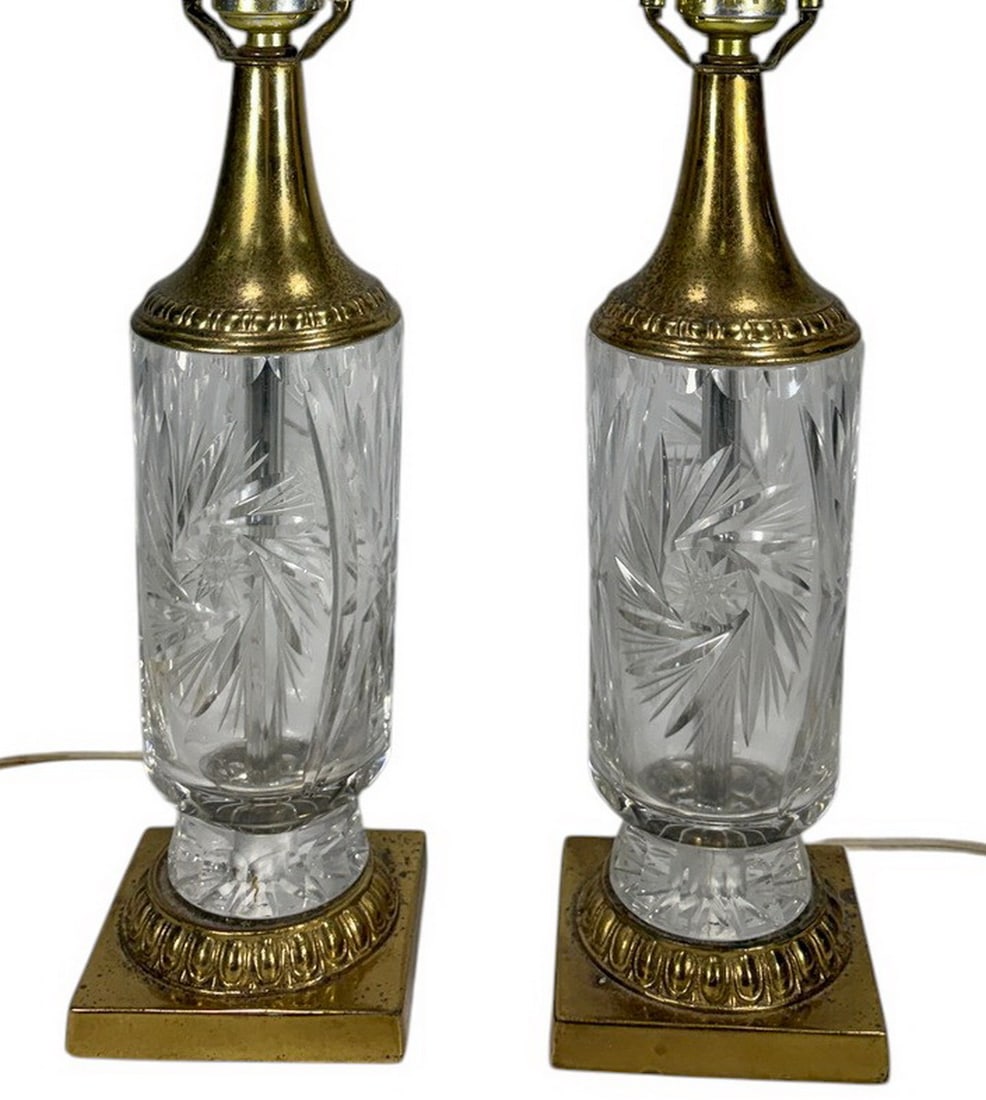 Pair of Cut Glass & Brass Starburst Table Lamps: Two-piece LOT of matching table lamps featuring cut glass bodies with starburst decoration, brass-tone metal mounts, square bases, and harp fittings. Each fitted with a single socket and electrical