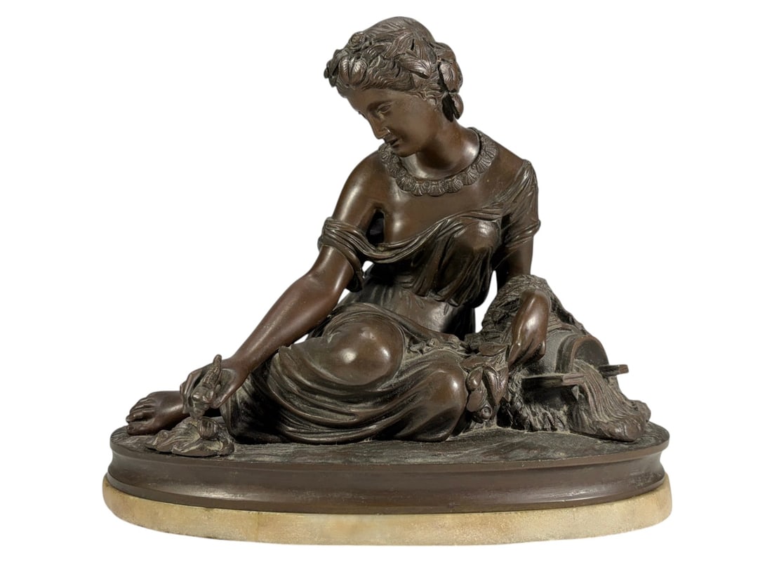 Neoclassical Bronze Figure of Seated Young Woman: Neoclassical bronze figure depicting a seated young woman in classical dress with a floral wreath in her hair. The figure leans forward in a contemplative pose and is surrounded by foliage and natural