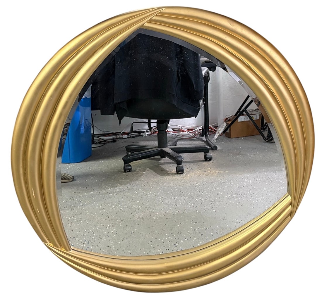Howard Elliott Collection Gold Tone Wall Mirror: Howard Elliott Collection wall mirror featuring a round mirror plate within a sculptural gold-tone frame composed of sweeping, layered curved bands. Original Howard Elliott Collection label affixed