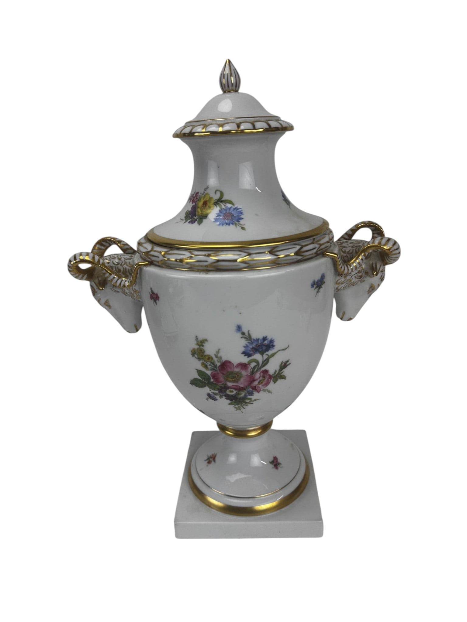 Furstenberg Porcelain Floral & Ram Head Lidded Urn: Large German porcelain covered urn featuring a baluster form body raised on a circular and square plinth. Decorated with colorful applied/ transfer floral bouquets and scattered floral sprigs against 
