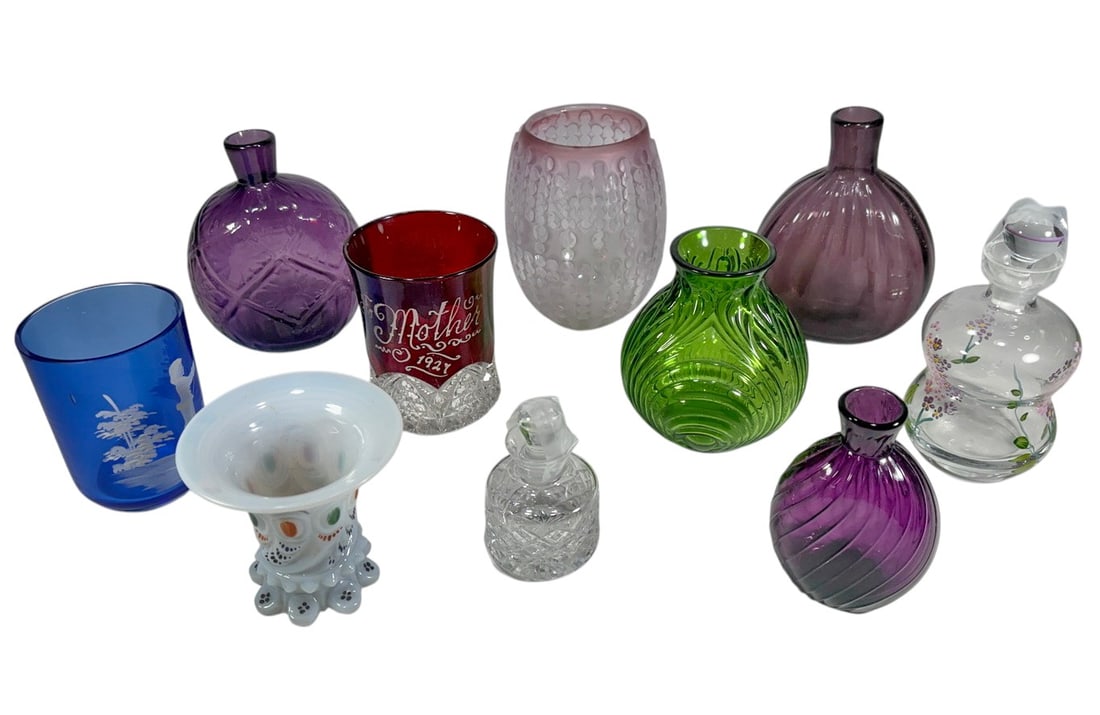 Assorted Colorful Art Glass Objects 10pc LOT: Ten-piece assortment of decorative art glass comprising three purple glass bottle-form vases, a red glass tumbler with etched inscription dated 1921, a cobalt blue etched tumbler, a green molded glass