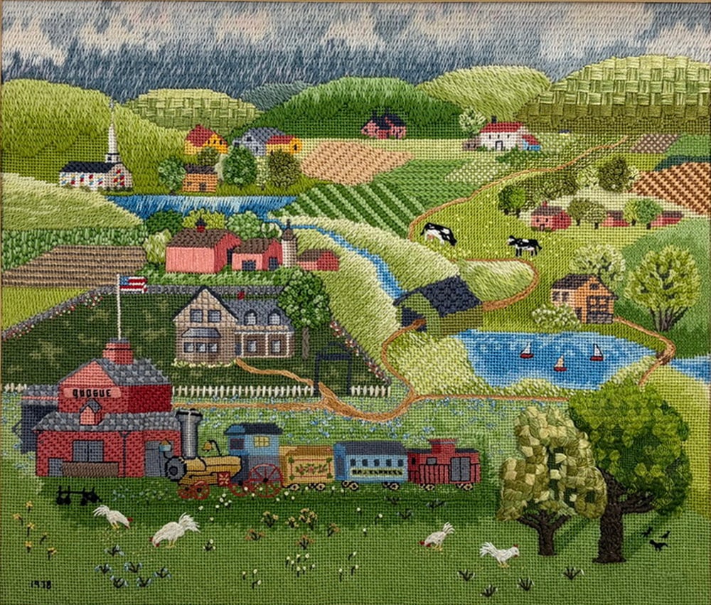American Folk Art Needlework Farm Landscape: American folk art needlework depicting a rural farm landscape with houses, barns, a church, fields, livestock, a pond with sailboats, trees, and a train in the foreground. Executed in multicolored thr