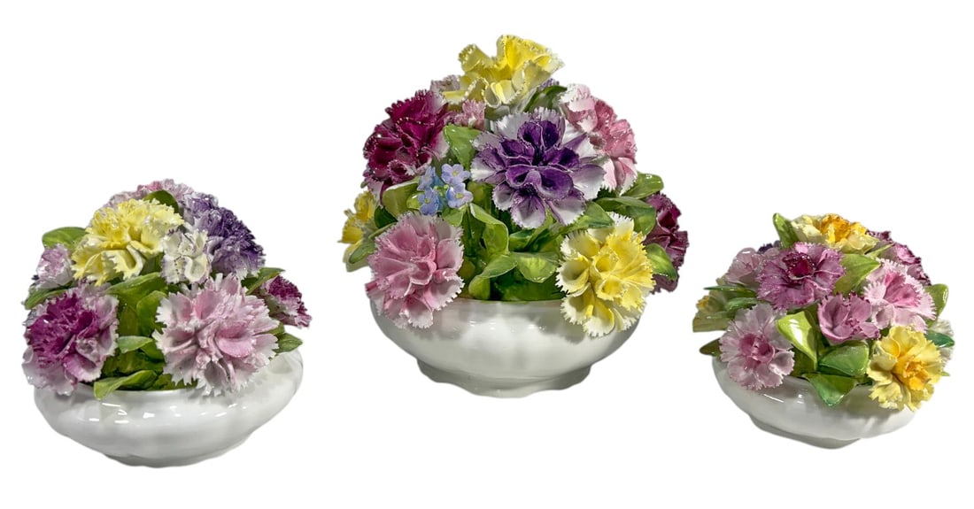 Coalport Porcelain Flower-Basket Figures 3pc LOT: Three-piece lot of English Coalport bone china flower basket figurines, each modeled as a low white basket or bowl overflowing with finely applied porcelain flowers and leaves. The arrangements featur