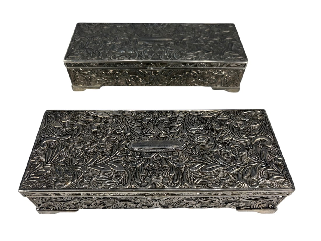 Ornate Silverplate Repousse Jewelry Boxes 2pc LOT: Pair of rectangular silverplate jewelry boxes with richly embossed foliate scroll decoration to the lids and sides. Hinged interiors are fitted with divided compartments, padded ring rolls, and inset 