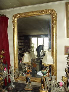 A Gilt Frame Mirror: Mirror with gilt frame and flowers. Early 20th century. Provenance: Important private collection, Dallas, Texas. 46 inches x 39 inches