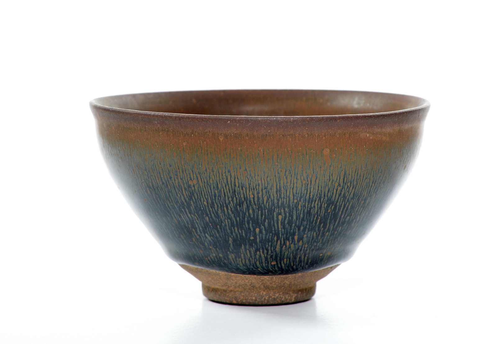 A Chinese "Jian" "Hare's-Fur" Tea Bowl: Sturdily potted bowl rising from a short foot to an indented slightly everted rim, covered overall in a glossy black glaze finely streaked in russet resembling hare's fur. D: 4 3/4 inches