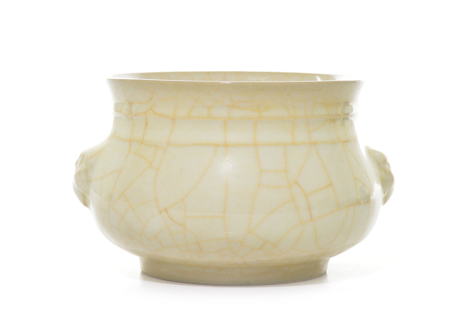 A Fine Chinese Guan-Type Porcelain Burner: Finely potted and rising from a straight foot to a narrow neck, decorated with pair of lion masks, covered overall with milk-yellow glaze suffused with golden crackles. Ming dynasty. D: 17 cm Conditio