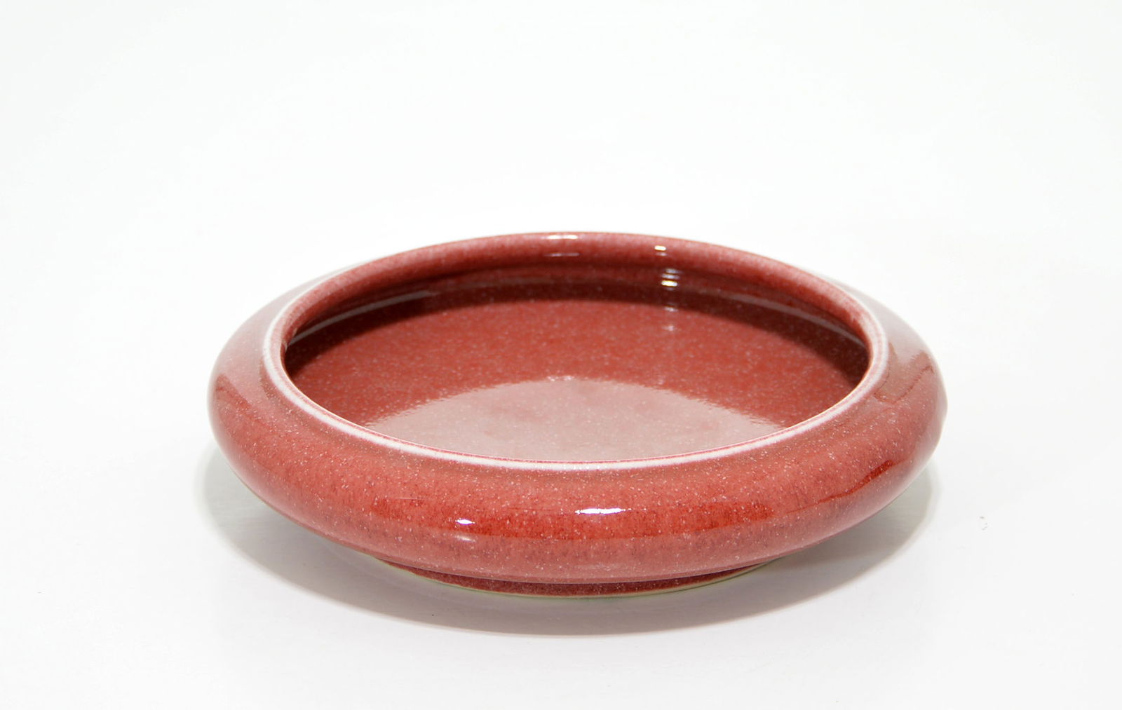 Chinese Copper-Red Brush Washer: Compressed body covered overall with with a glaze of soft, crushed-strawberry-red color ending in a line on the ring foot. Kangxi mark on base. D:14 CM, 5 1/2 IN