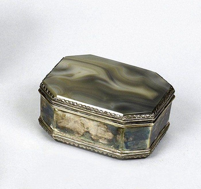 Fine Banded Agate Snuff Box: Octagonal box constructed with panels of gray and brown banded stone set into a white metal frame. The top lid features a single flat piece of stone with natural wave patterns. Small decorative