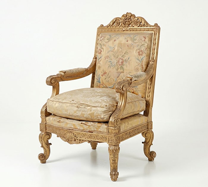 Giltwood Armchair: Armchair with a brass colored frame and floral patterned fabric. The frame features carved ornamentation on the legs and backrest. H: 84 CM