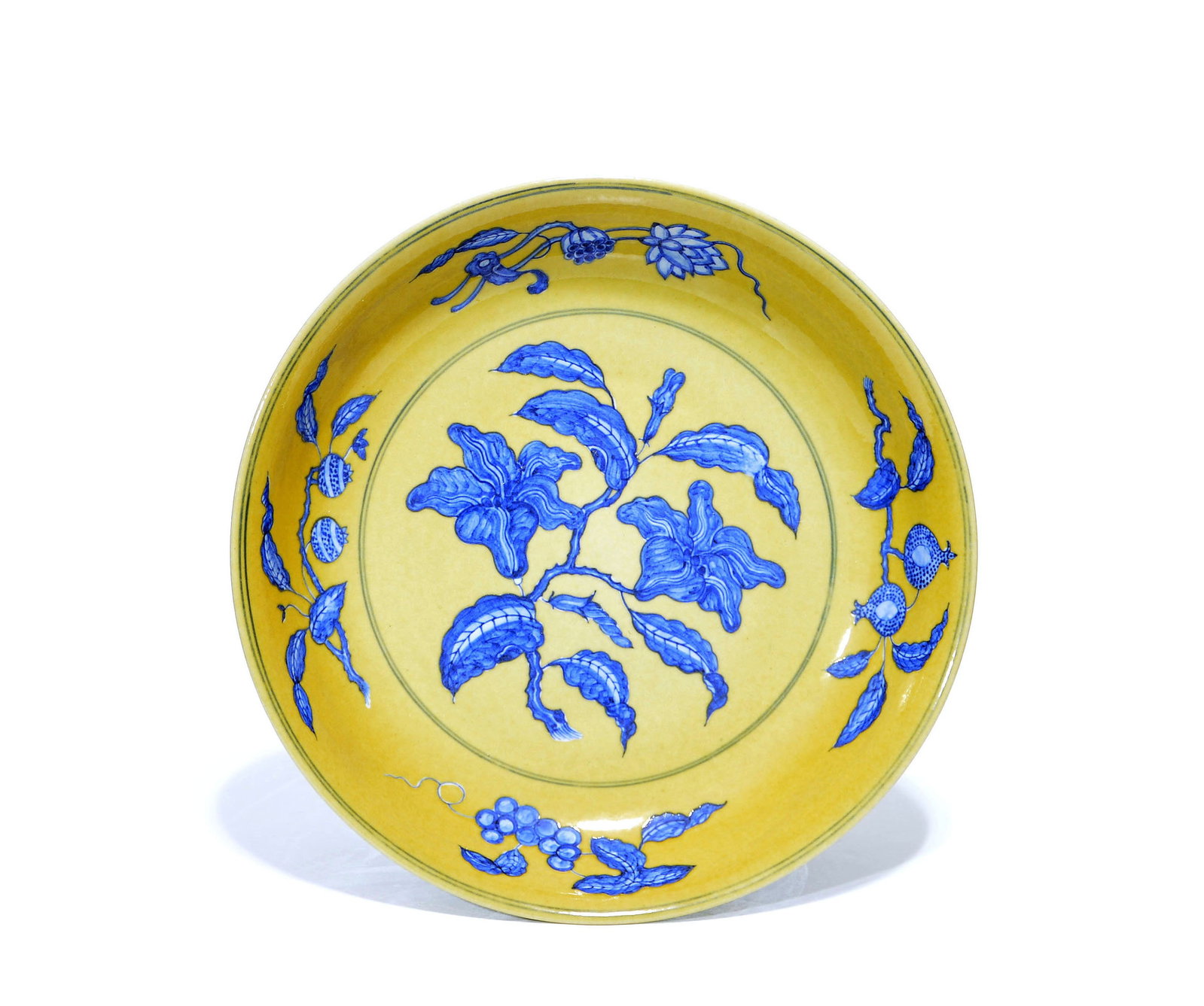 Fine Chinese Yellow-Enamel 'Gardenia' Dish: Yellow ceramic dish decorated with blue floral and fruit motifs. Interior features a central floral spray surrounded by various branches of fruit and flowers along the inner rim. Shallow circular