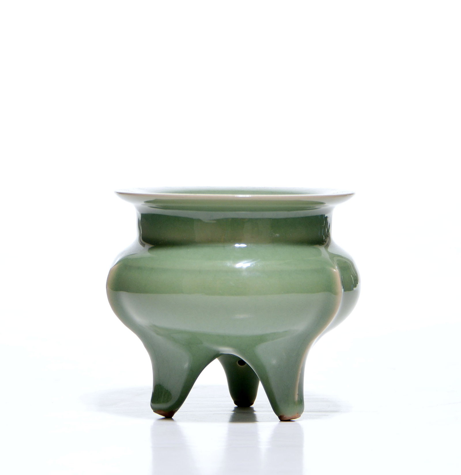 Fine Chinese Celadon Incense Burner: This elegant tripod incense burner is sturdily potted in imitation of an archaic bronze li vessel, featuring a compressed globular body divided into three distinct sculptural lobes. Each lobe tapers
