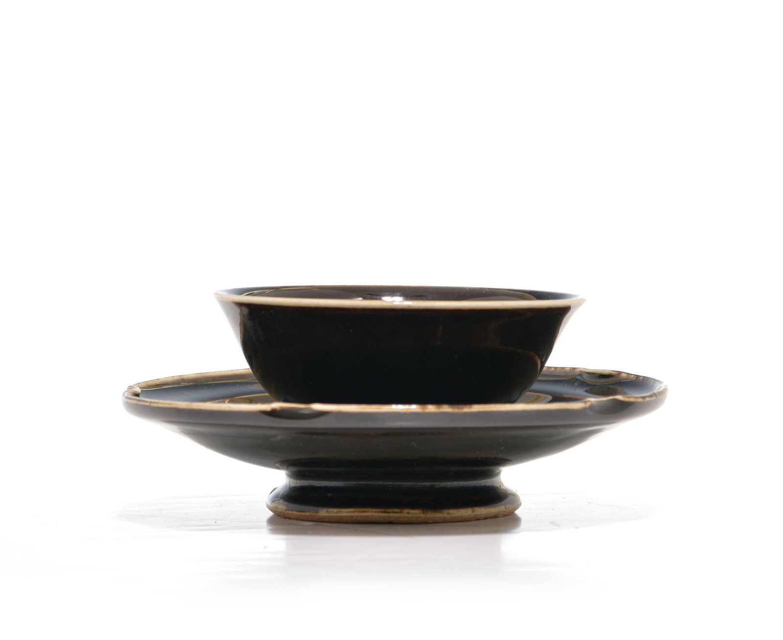 Chinese Dark Glazed Bowl: Bowl and matching stand of sophisticated profile, characterized by an obsidian-toned glaze that flows with liquid grace over the well-potted forms. The vessel is defined by its flared rim and a deep,