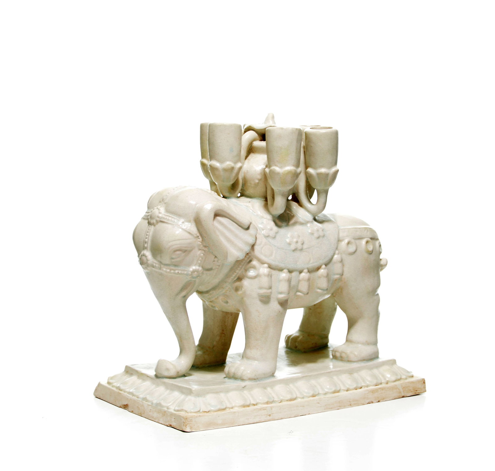 Exceptionally Rare Chinese Sui-Dynasty White-Glaze Elephant Candle Stick: Elephant figure modeled standing atop a rectangular plinth, the pachyderm supporting a central vessel flanked by four smaller candle nozzles. The animal is caparisoned with an ornate saddlecloth featu