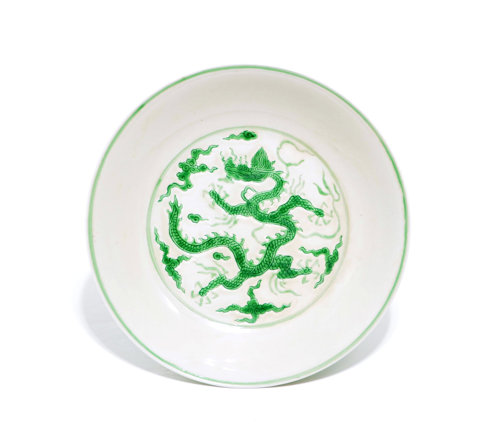 Chinese Green-Enamel Dragon Dish: Dish of shallow form with rounded sides, the interior meticulously decorated with a central medallion featuring a sinuous dragon writhing amidst stylized clouds in vibrant green enamel. The exterior i