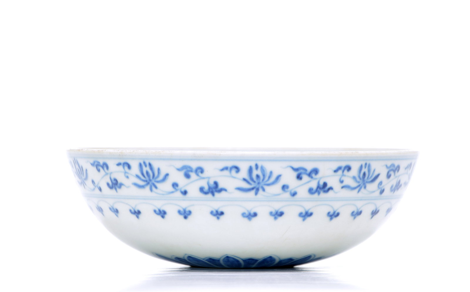 Rare Chinese Blue And White Bowl: Bowl of refined hemispherical form, the exterior elegantly rendered in underglaze blue with a continuous scrolling vine of stylized lotus blossoms above a delicate border of ruyi heads. The interior f