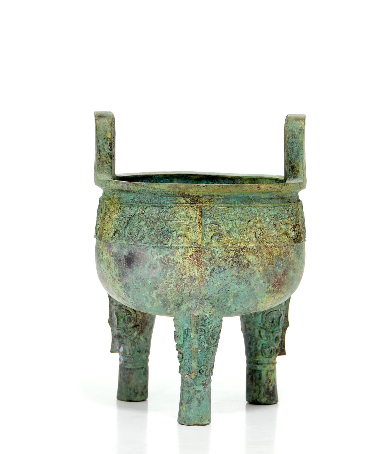 Rare Chinese Bronze Tripod Ritual 'Ding' Vessel: Bronze ritual tripod vessel, ding, of robust proportions, featuring a deep rounded body supported on three cylindrical legs cast with stylized masks and vertical flanges. The exterior is meticulously 
